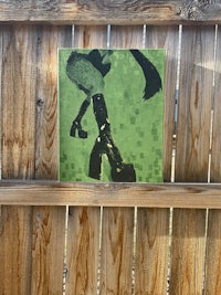 a picture of a man on a skateboard hanging on a wooden fence